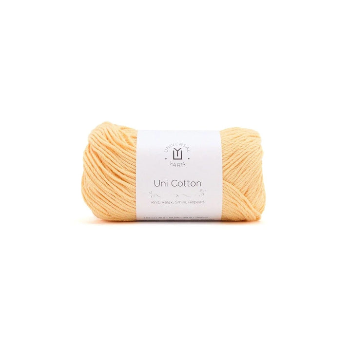 A single skein of soft peach-colored yarn with a white paper label, centered on a plain white background.